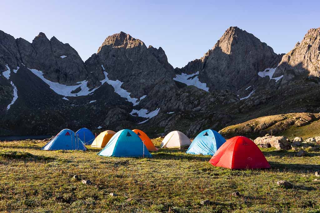 Colourful trekking tents set below rocky peaks
