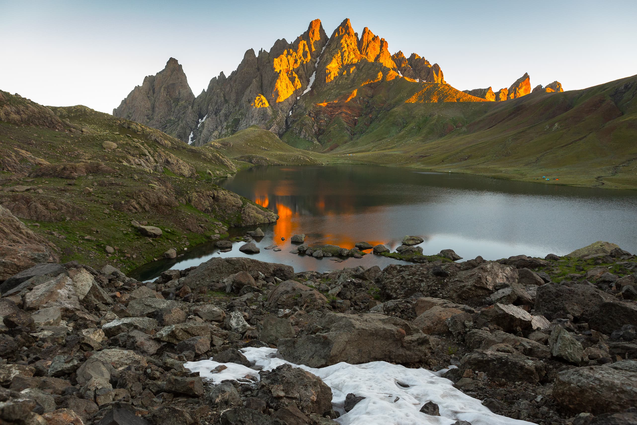 Mountain lake reflecting the peaks in warm evening light