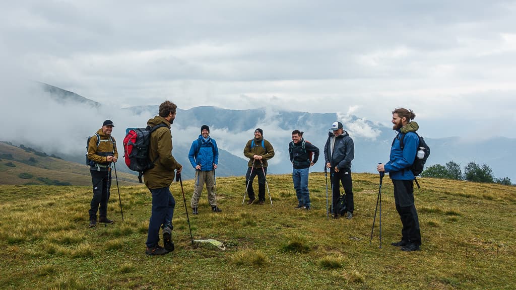 A trekking group gathered on a grassy ridge