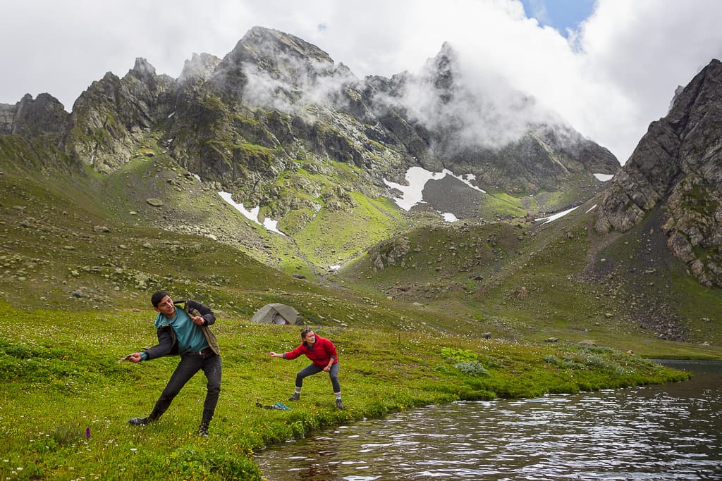 Trekkers walking through a green mountain valley